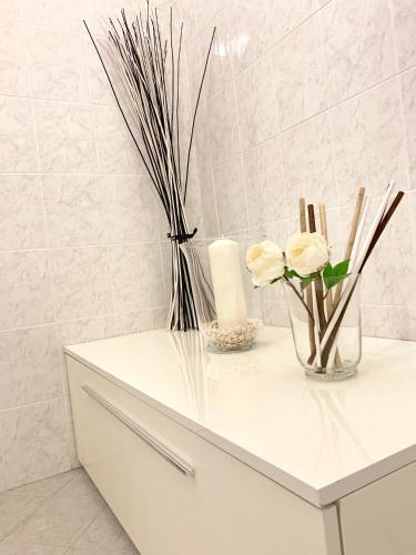 a white cabinet with flowers and candles on it at Indipendenza Luxury Apartments in Bologna