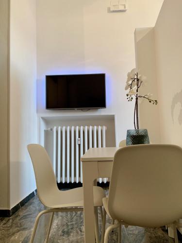 a dining room with a table and chairs and a tv at Indipendenza Luxury Apartments in Bologna