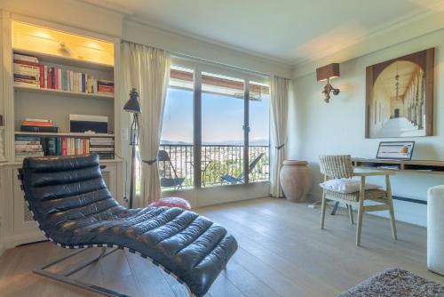 - un salon avec une chaise et un bureau offrant une vue dans l'établissement Les Pins Tranquilles, à Cannes