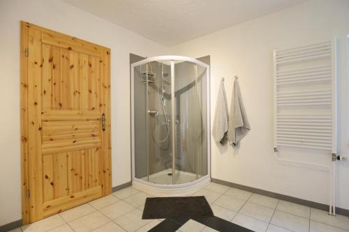een badkamer met een douche en een houten deur bij Ferienwohnung Harzurlaub-Schierke in Schierke