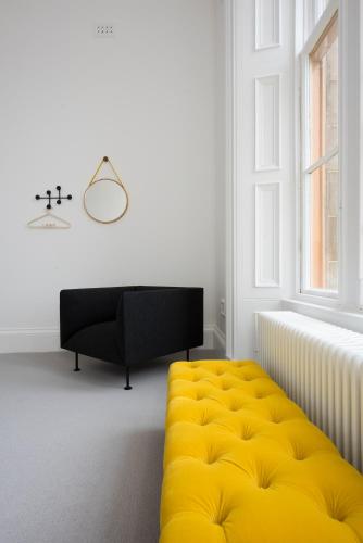 a living room with a yellow ottoman and a couch at Lews Castle in Stornoway