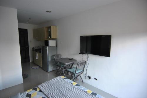 a room with a bed and a television on a wall at The Uptown Place Condominium in Iloilo City