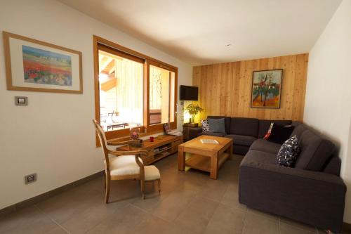 a living room with a couch and a table at L'Eyssaben Appartement de grand standing à Serre-Chevalier in Le Monêtier-les-Bains