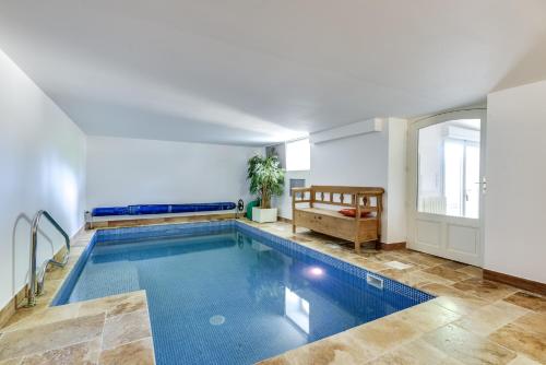 een groot zwembad in een witte kamer met bij SUITE Souplex Château Côte de Nacre in Ver-sur-Mer