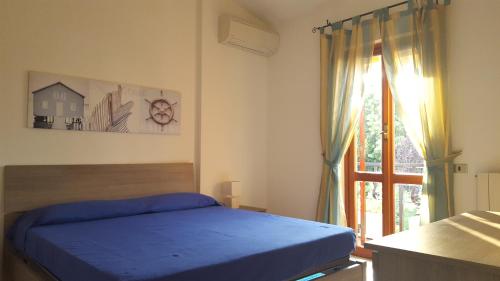 a bedroom with a blue bed and a window at Villa Malu in Anzio