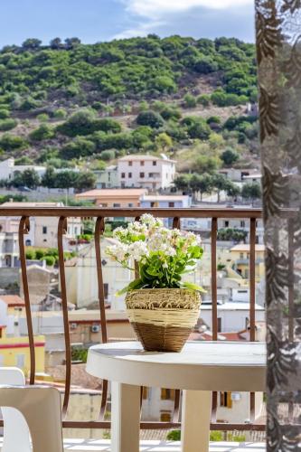 a table with a basket of flowers on a balcony at Su Pranu in Onifai