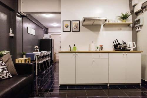 a kitchen with white cabinets and a couch in a room at T2 2 Bedrooms 6 guests Full kitchen 1 min to BTS in Bangkok