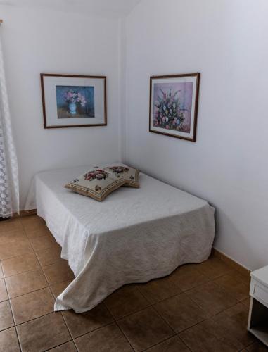 a bed in a room with two pictures on the wall at Su Pranu in Onifai