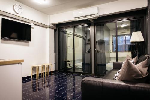 a living room with a couch and a tv at T2 2 Bedrooms 6 guests Full kitchen 1 min to BTS in Bangkok