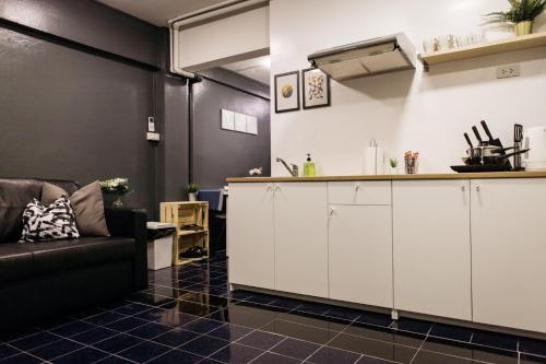 a living room with a couch and a kitchen at T2 2 Bedrooms 6 guests Full kitchen 1 min to BTS in Bangkok