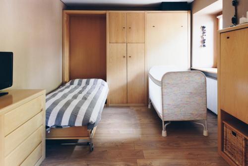 a small bedroom with a bed and a chair at MAISON LINDA in Sottoguda