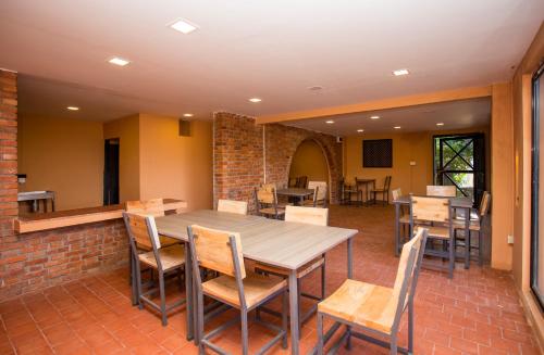 a dining room with a wooden table and chairs at Depche Village Resort in Bandīpur