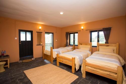 a row of beds in a room with windows at Depche Village Resort in Bandīpur