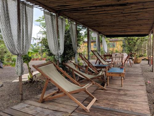 un grupo de sillas sentadas en una terraza de madera en Bohemyan Blue Stay, en Alibaug