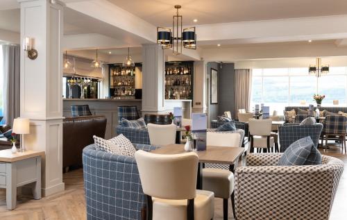 a restaurant with blue and white chairs and tables at Loch Ness Clansman Hotel in Drumnadrochit