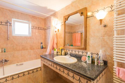 W łazience znajduje się umywalka, wanna i lustro. w obiekcie Pool villa near to airport/free car available w mieście Pikérmion