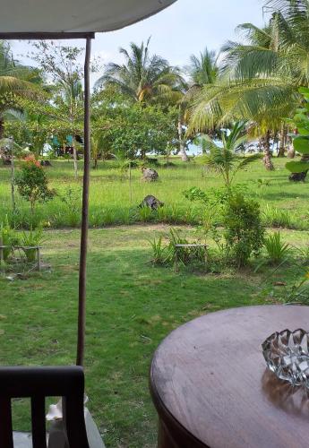 a table with an umbrella next to a field at Mutiara Beach Resort in Berakit