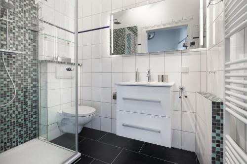 a bathroom with a toilet and a sink and a shower at Herr Friese, Wohnung Nr. 6 in Norderney