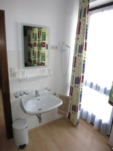 a white bathroom with a sink and a mirror at Pension Lang in St. Andrä am Zicksee