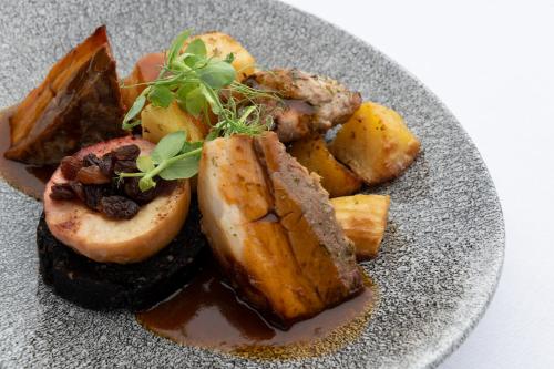 a plate of food with potatoes and meat on it at Loch Ness Clansman Hotel in Drumnadrochit