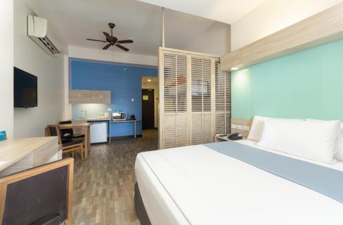 a bedroom with a large bed and a kitchen at Microtel by Wyndham Mall of Asia in Manila