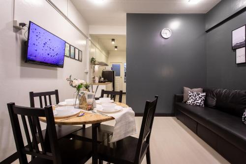 T5 2 Bedrooms/6guests/full kitchen/1 min to BTS في بانكوك: غرفة طعام وغرفة معيشة مع طاولة وأريكة