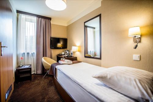 a hotel room with a bed and a mirror at Hotel Diament Zabrze - Gliwice in Zabrze