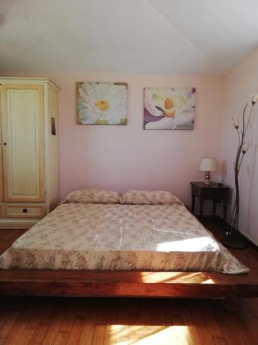 um quarto com uma cama e três fotografias na parede em Villino Verde Pomodoro em Arezzo