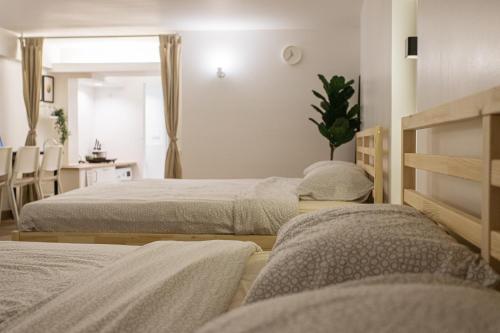 a bedroom with two beds and a table with a desk at B2 Large + Comfort full kitchen near MRT Bangson in Bangkok