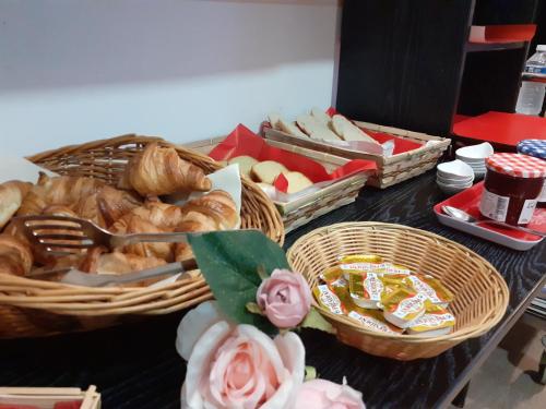 a table topped with baskets of bread and pastries at Hotel les Tourrades in Cannes