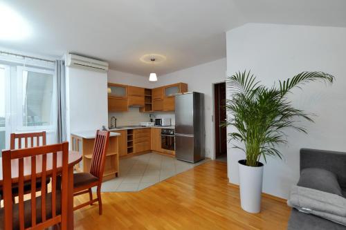 een keuken en een woonkamer met een tafel en een koelkast bij Apartament Słoneczny 2 in Opole