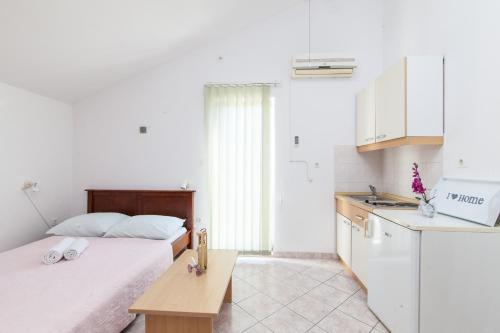 1 dormitorio con 2 camas y cocina con fregadero en Apartmani Villa Mimi, en Brodarica