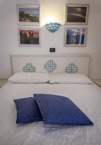 a white bed with a blue pillow on it at Su Pranu in Onifai