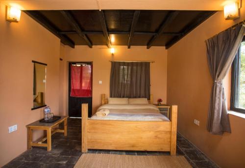 a bedroom with a bed with a wooden bed frame at Depche Village Resort in Bandīpur