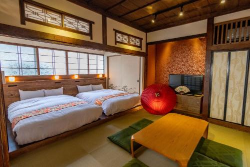 a bedroom with two beds and a tv and a table at Ebisumachi Takadaya in Hakodate