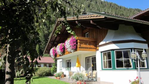 a house with flowers on the balcony at Ferienwohnungen Drexel in Elbigenalp