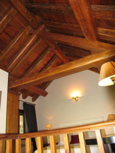 a wooden ceiling in a living room with wooden beams at Villa Russell Hotel&Apartments in Torla