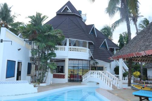 a house with a swimming pool in front of a building at A wonderful Beach property in Diani Beach Kenya.a dream holiday place. in Mombasa