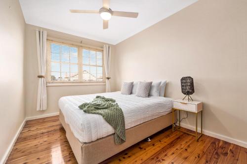 a bedroom with a bed and a ceiling fan at Memories On Mount View, Games Room, Cosy Wood Fire, Netflix in Cessnock