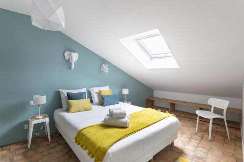 - une chambre avec un lit aux murs jaunes et bleus dans l'établissement Le Nao- L'Île Feydeau - 2 chambres de charme, à Nantes