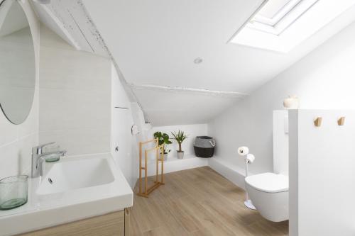 une salle de bain blanche avec un lavabo et des toilettes dans l'établissement Le Nao- L'Île Feydeau - 2 chambres de charme, à Nantes