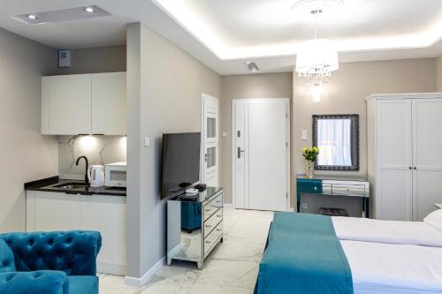 a hotel room with a bed and a kitchen at Apartamenty Prestiż 93 in Koszalin