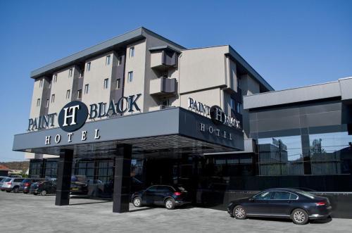 a hotel with cars parked in front of it at Paint It Black Hotel & Spa in Gevgelija
