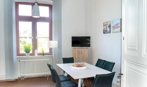 a dining room with a white table and chairs at Wohnung in TOP-Lage - Direkt am Bahnhof in Bad Wimpfen