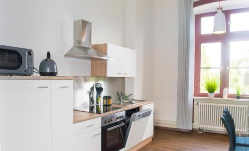 uma cozinha com armários brancos e um forno com placa de fogão em Wohnung in TOP-Lage - Direkt am Bahnhof em Bad Wimpfen