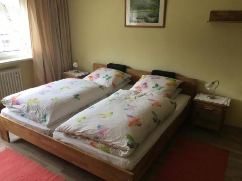 1 dormitorio con 2 camas con sábanas blancas y flores en Gästehaus Erna Meier en Bayerisch Eisenstein