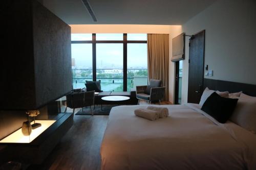 五結郷にあるTsang Kuo Resortの大きな窓付きの大きなベッドが備わるホテルルームです。