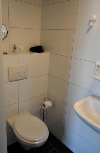 a white bathroom with a toilet and a sink at De Gusto in Schiedam
