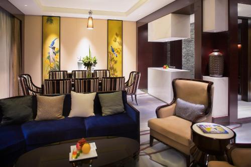 a living room with a blue couch and chairs at Movenpick Hotel Enshi in Enshi