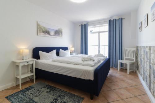 een slaapkamer met een blauw bed en een raam bij Villa Regina Maris Whg28 in Bansin
